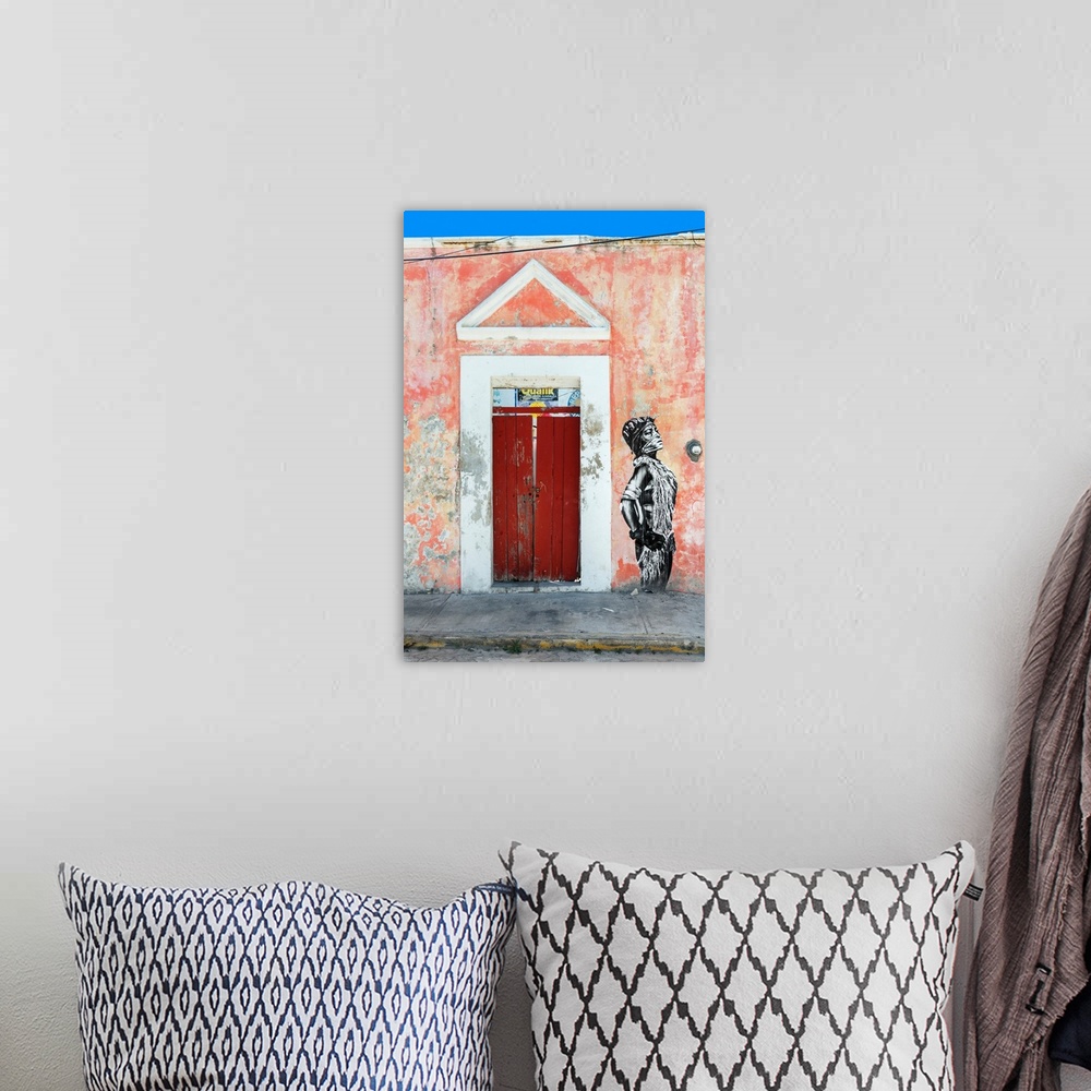 A bohemian room featuring Photograph of the exterior of a building with a red door and graffiti of a woman spray painted on...