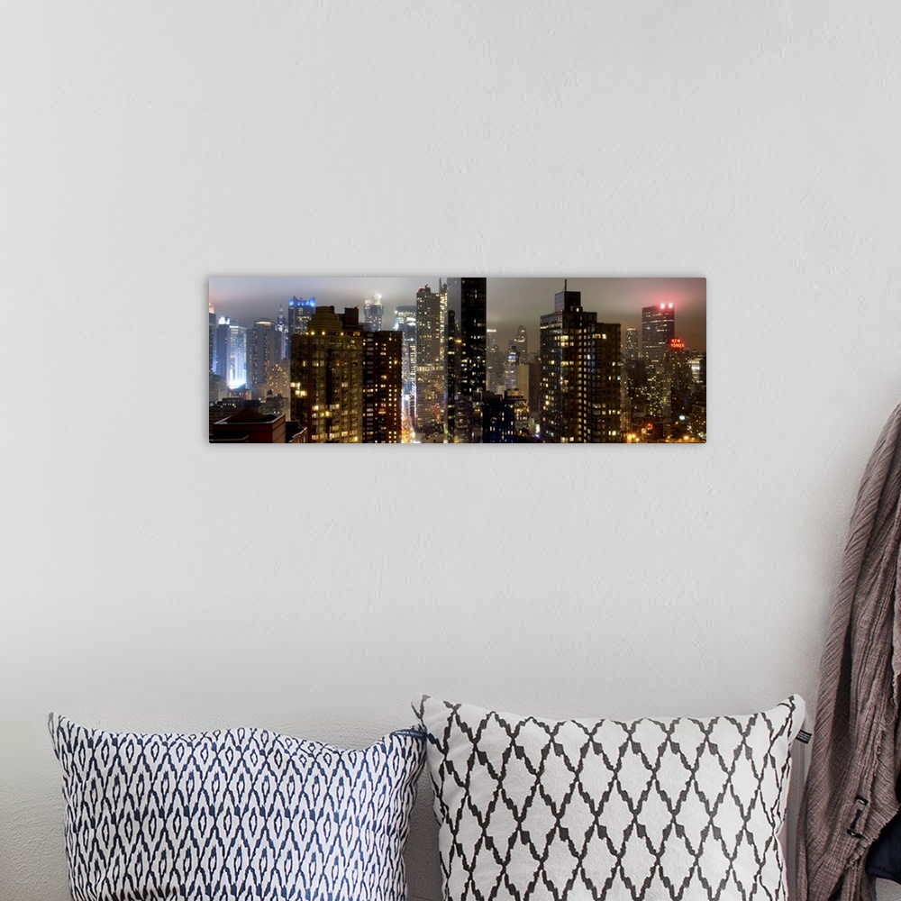 A bohemian room featuring Panoramic photo of the New York city skyline with skyscrapers lit up at night.
