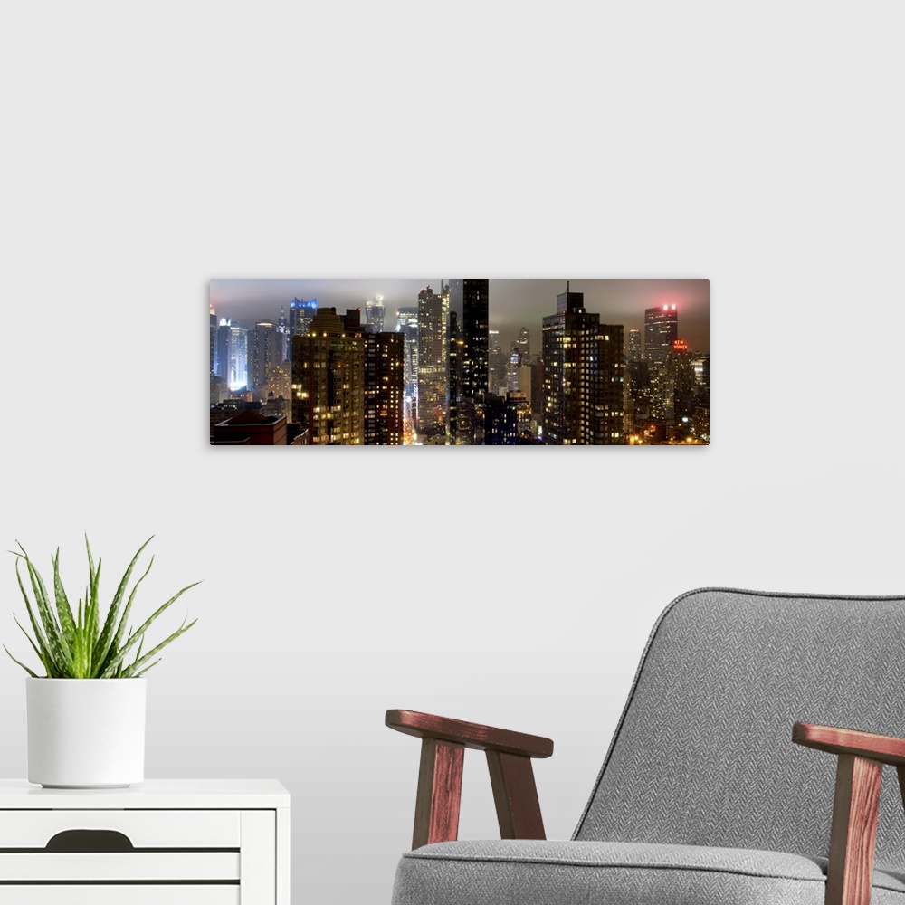 A modern room featuring Panoramic photo of the New York city skyline with skyscrapers lit up at night.
