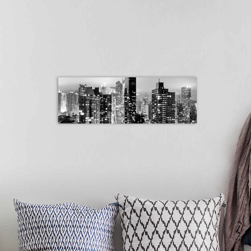 A bohemian room featuring Panoramic photo of the New York city skyline with skyscrapers lit up at night.