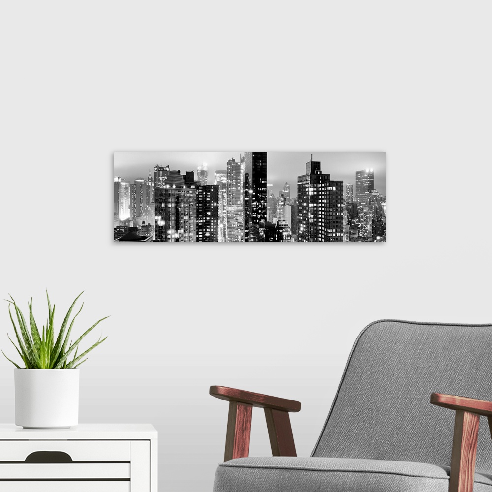 A modern room featuring Panoramic photo of the New York city skyline with skyscrapers lit up at night.