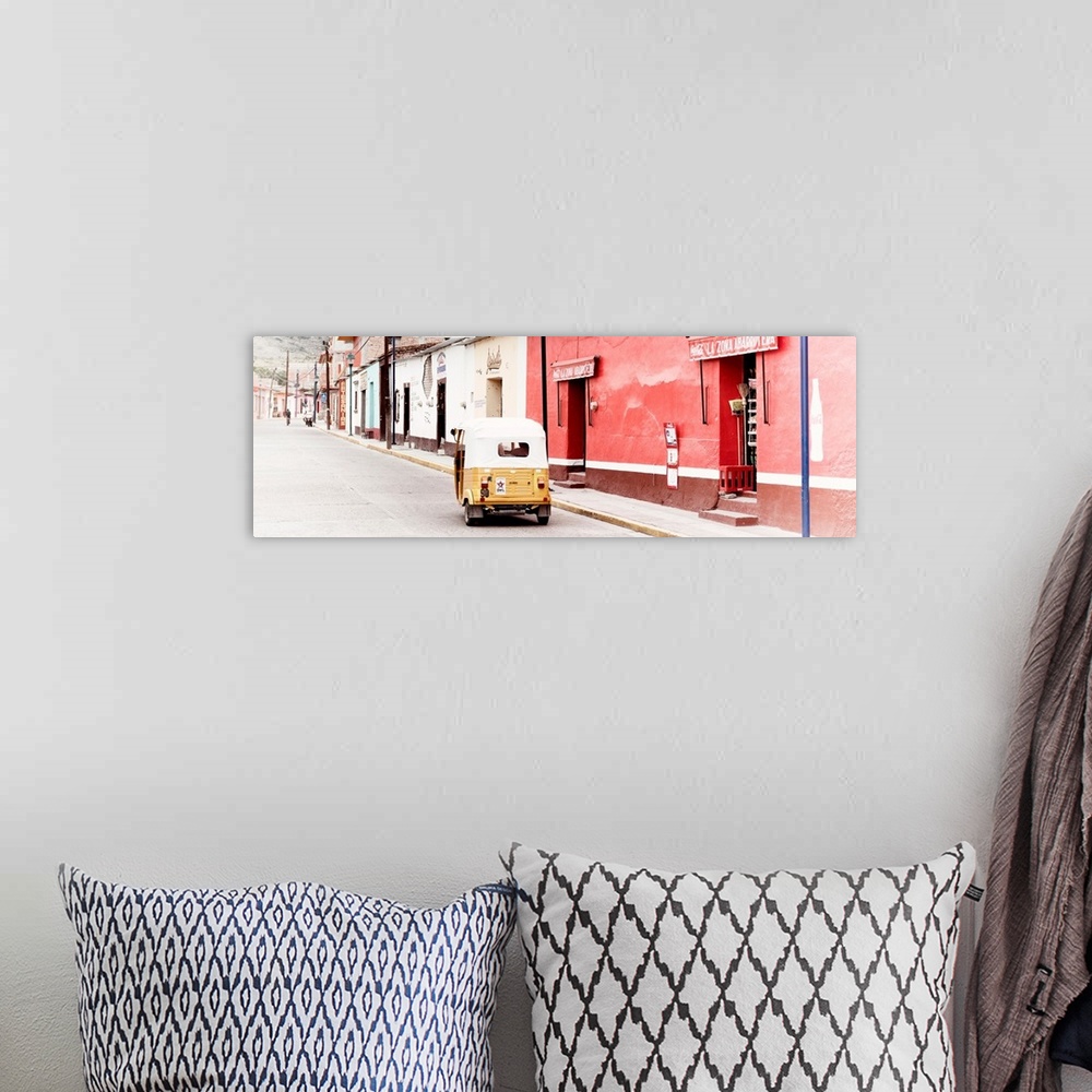A bohemian room featuring Panoramic photograph of a street scene in Mexico with a yellow tuck tuk (taxi) driving up the roa...