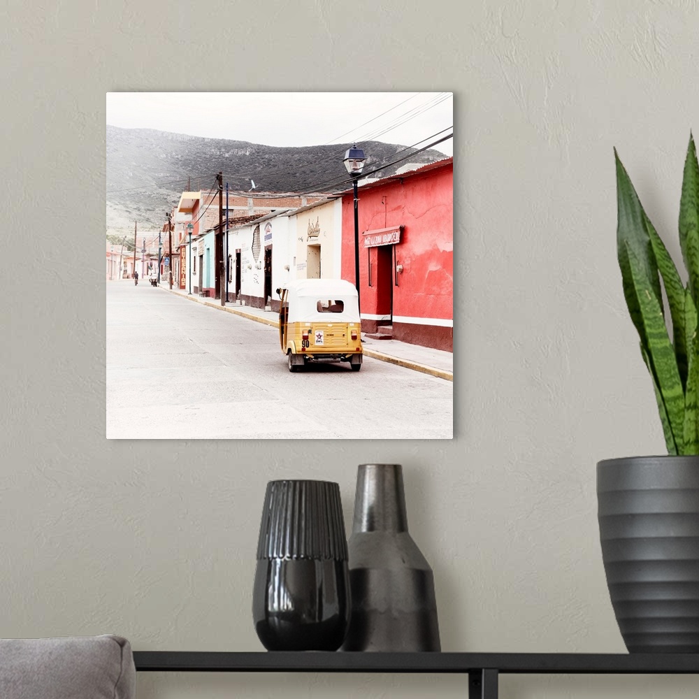 A modern room featuring Square ashed out photograph of a Mexican street scene with a yellow Tuk Tuk on the road. From the...