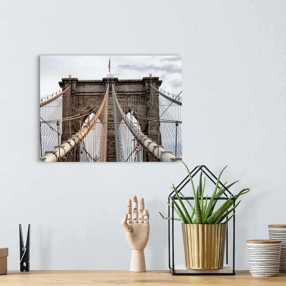 A bohemian room featuring A photograph of the Brooklyn bridge upper section.