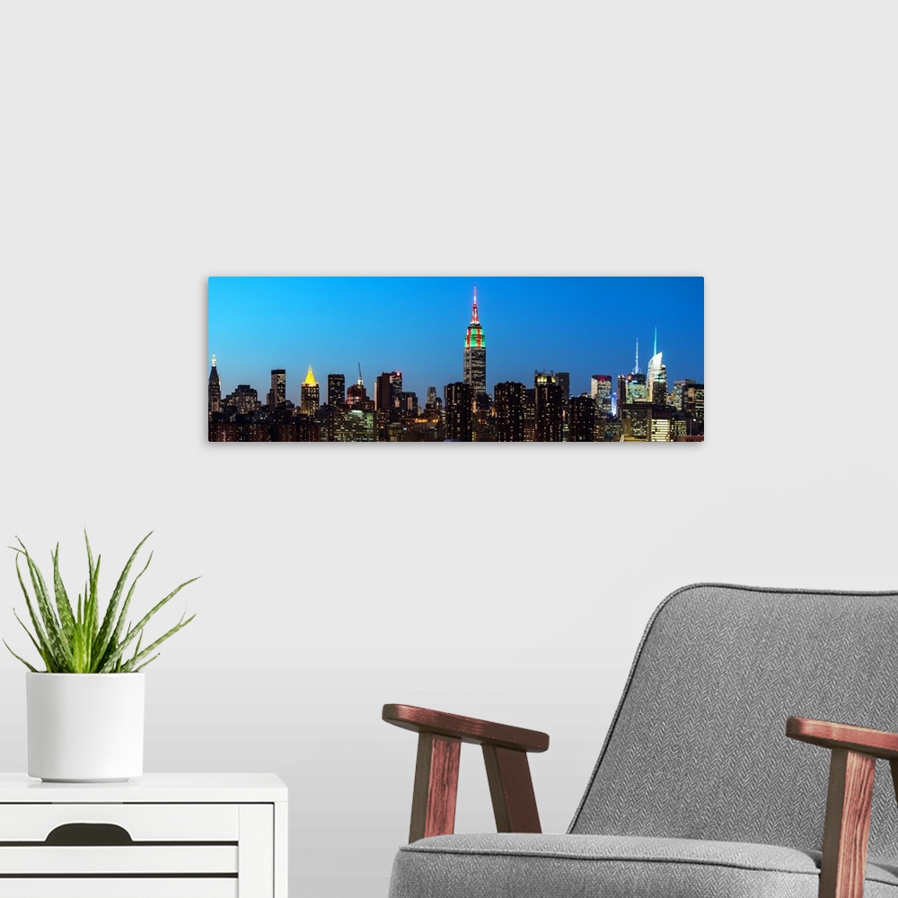 A modern room featuring A photograph of the New York city skyline at night, with the Empire state building standing tall.