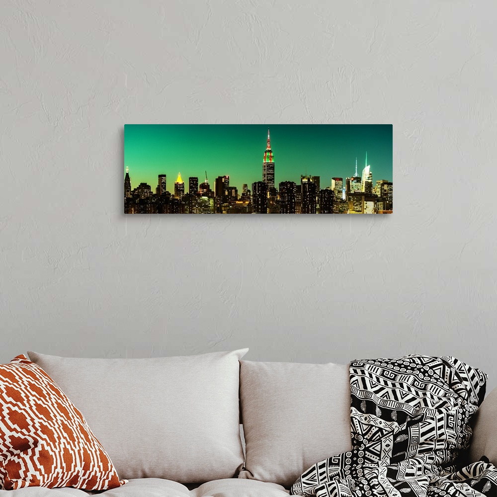 A bohemian room featuring A photograph of the New York city skyline at night, with the Empire state building standing tall.