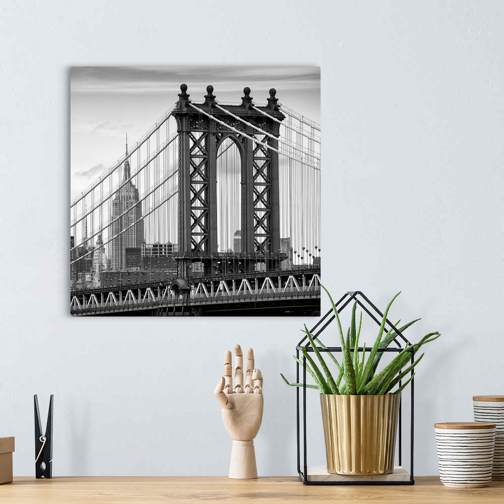 A bohemian room featuring A black and white photograph of the Manhattan bridge, with the Empire state building in the backg...