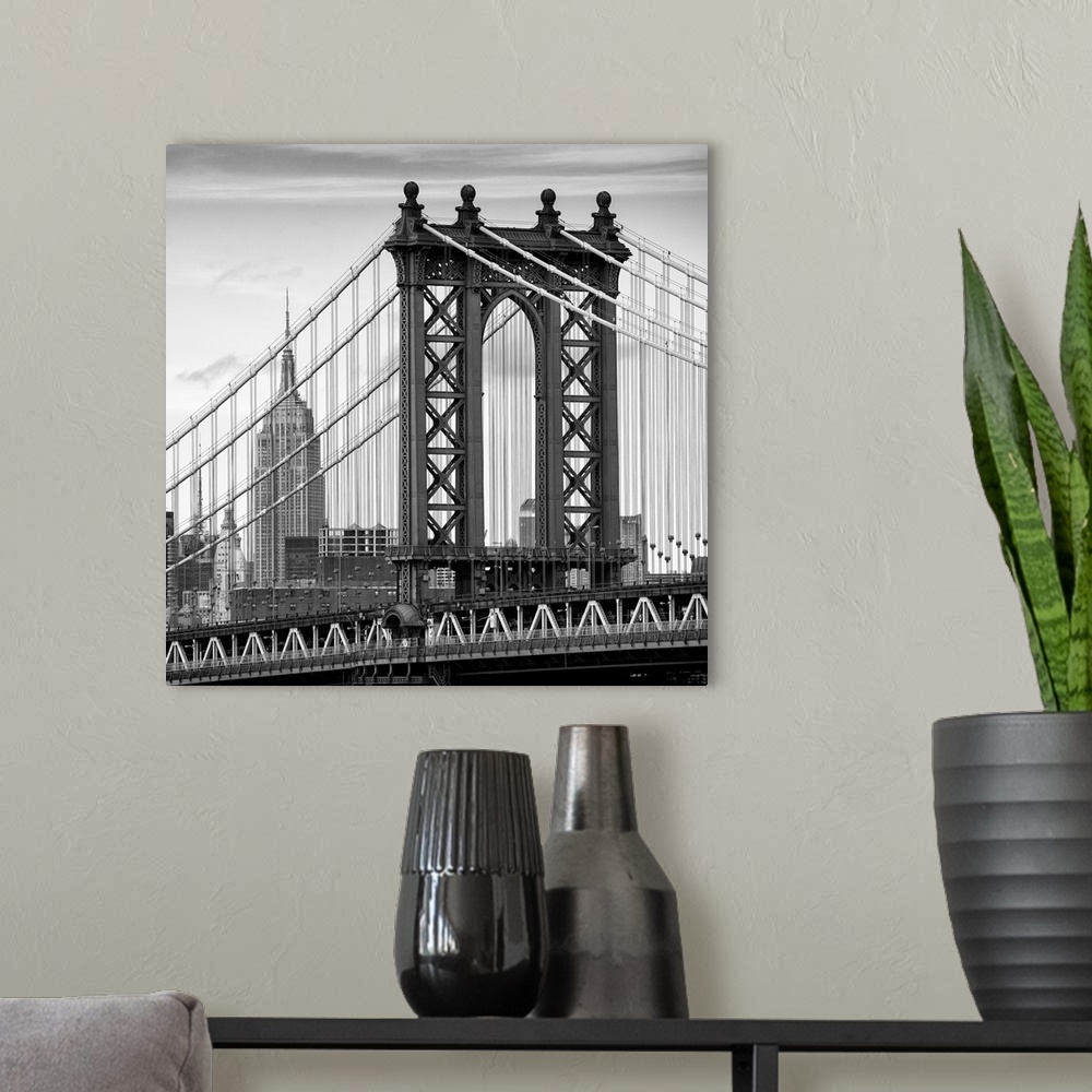 A modern room featuring A black and white photograph of the Manhattan bridge, with the Empire state building in the backg...