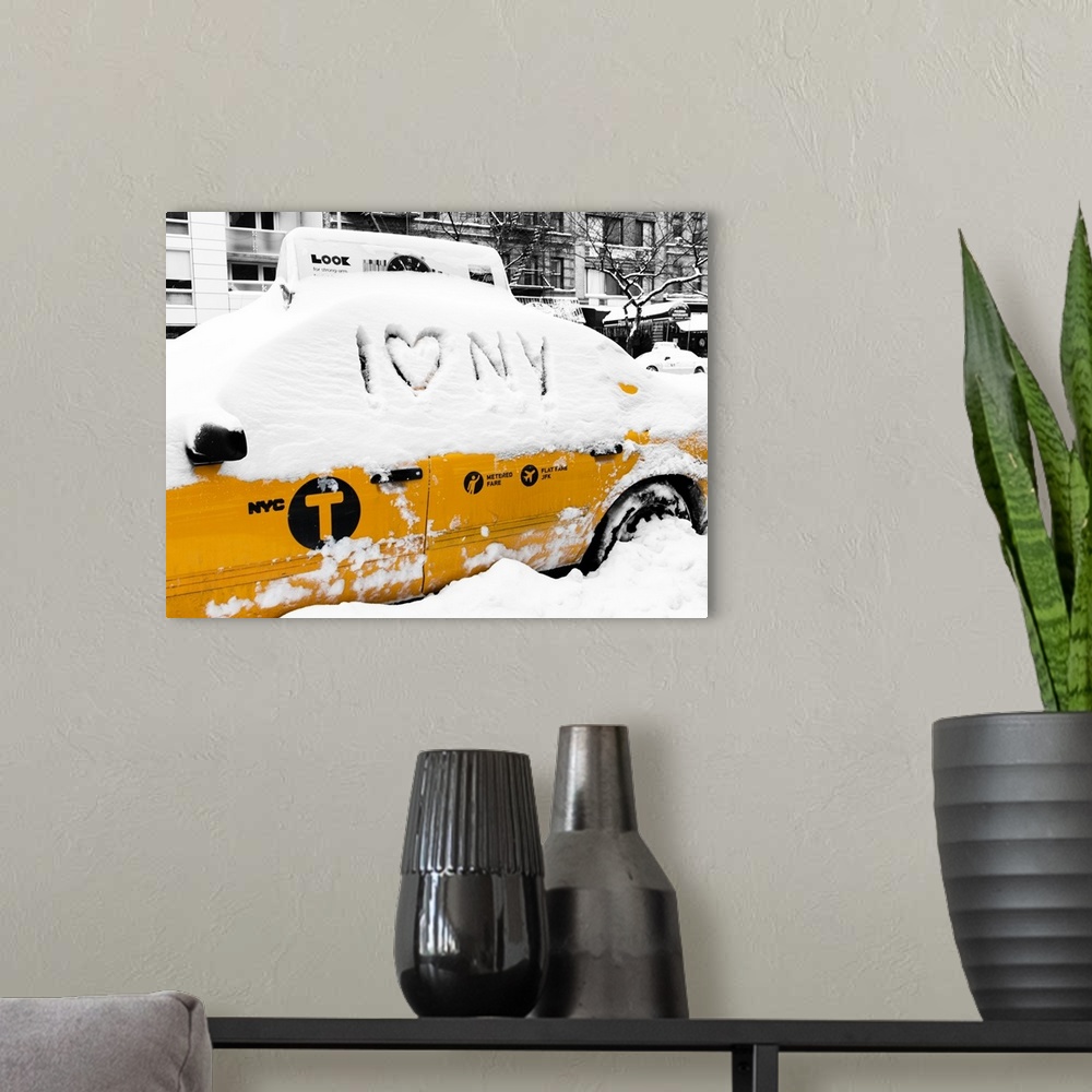 A modern room featuring A photograph of a yellow taxi cab in Manhattan in winter.