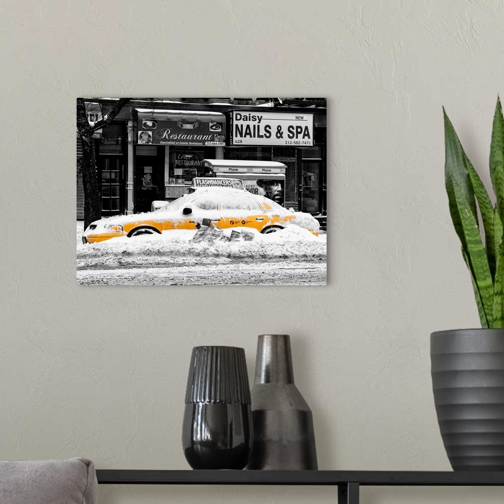 A modern room featuring A photograph of a yellow taxi cab in Manhattan in winter.