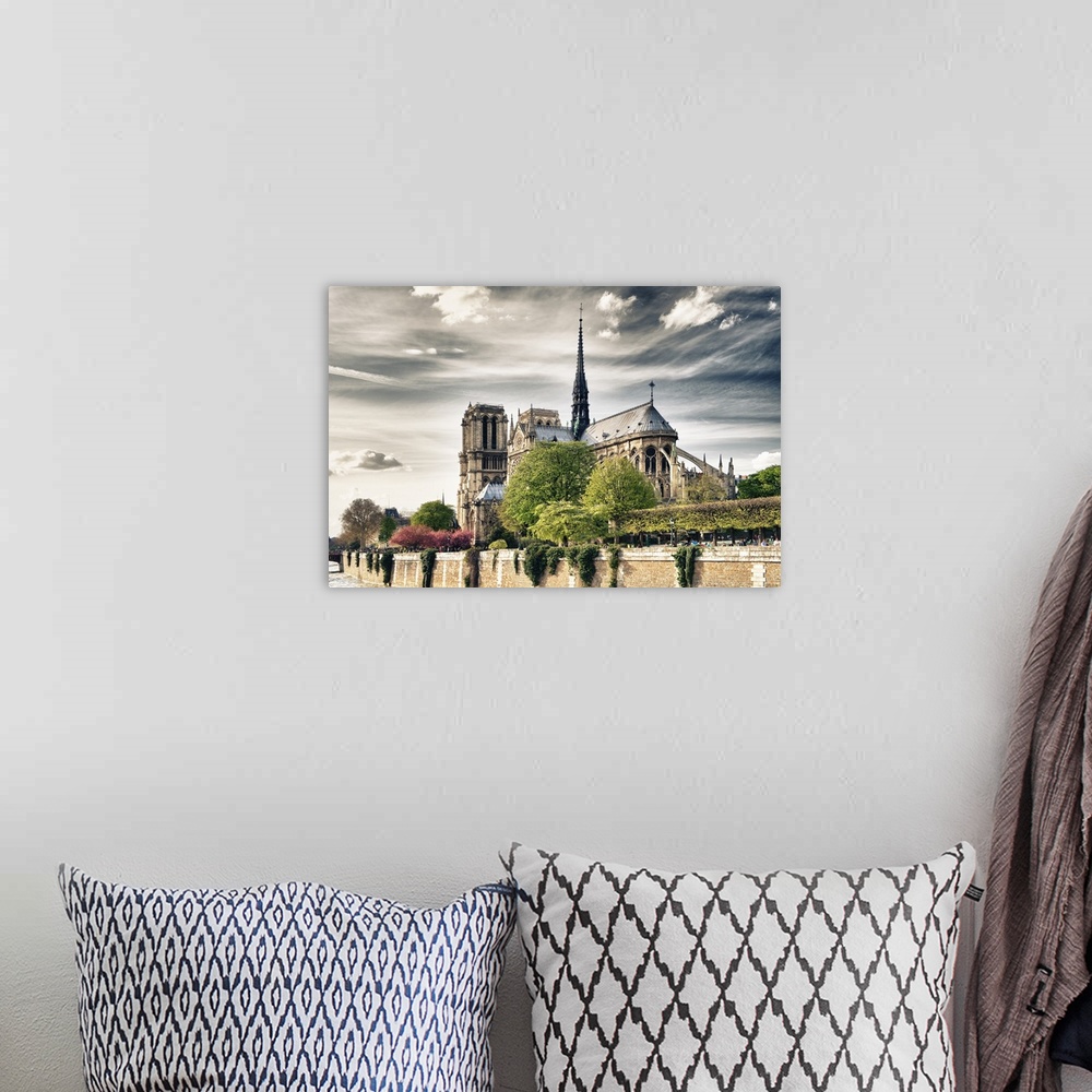 A bohemian room featuring Fine art photo of the Notre Dame Cathedral under a cloudy sky.