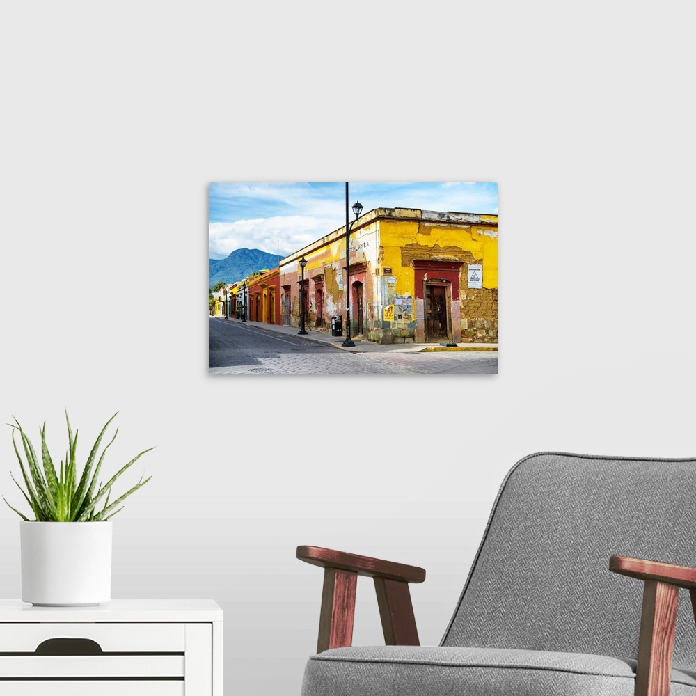 A modern room featuring Photograph of a bright city street in Oaxaca, Mexico, with a view of mountains in the background....