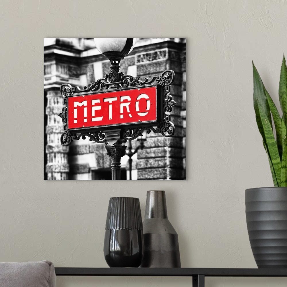 A modern room featuring Sign for an entrance to a Paris Metro station, or subway.