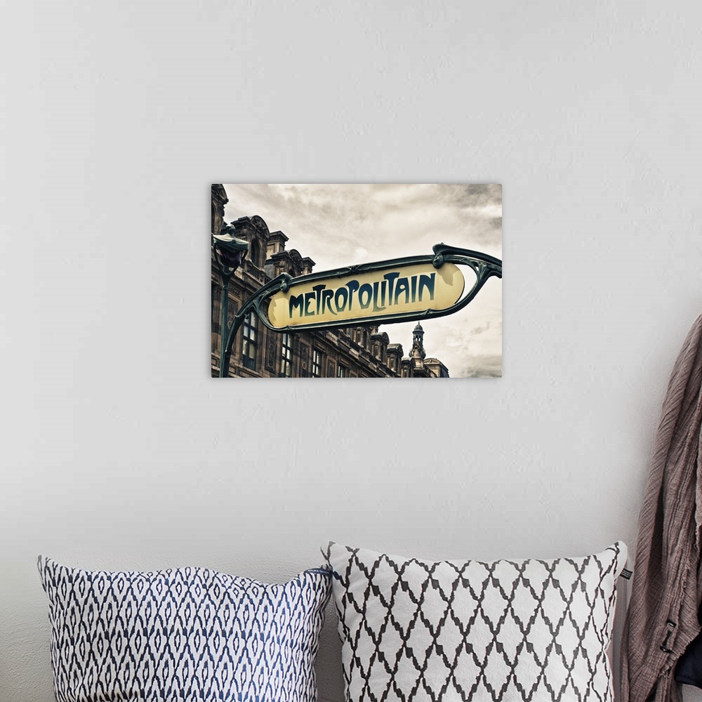 A bohemian room featuring Sign for an entrance to a Paris Metro station, or subway.