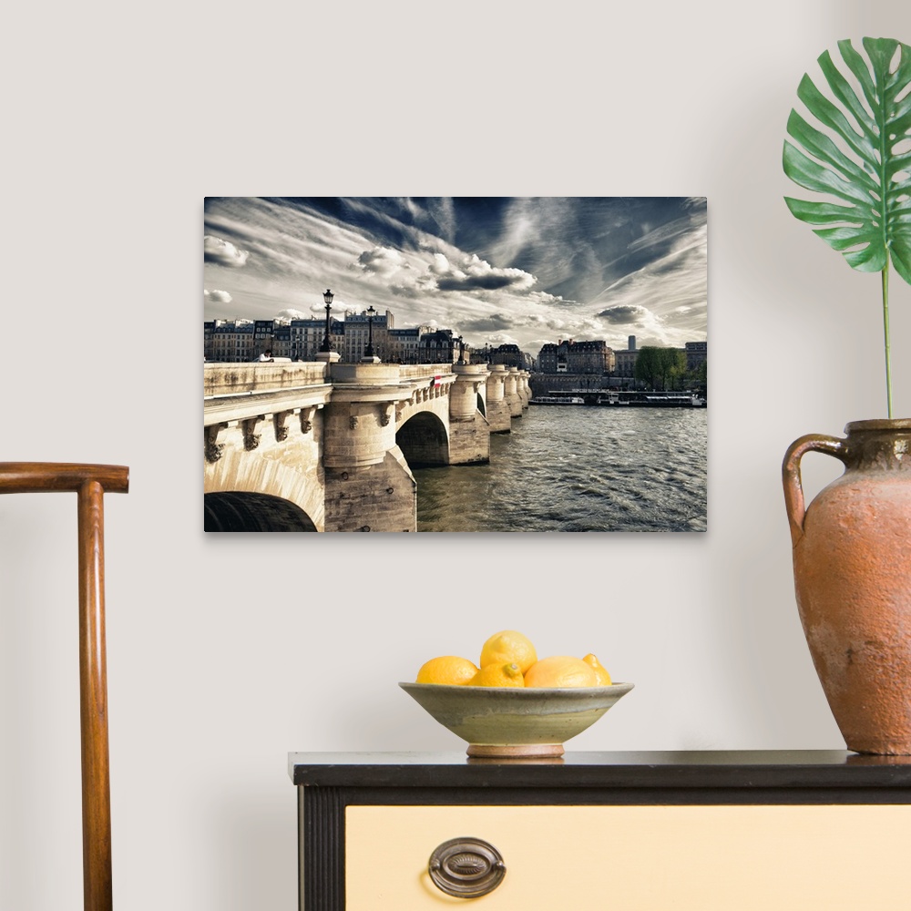 A traditional room featuring Arched bridge over the Seine River at sunset with stunning clouds in Paris, France.