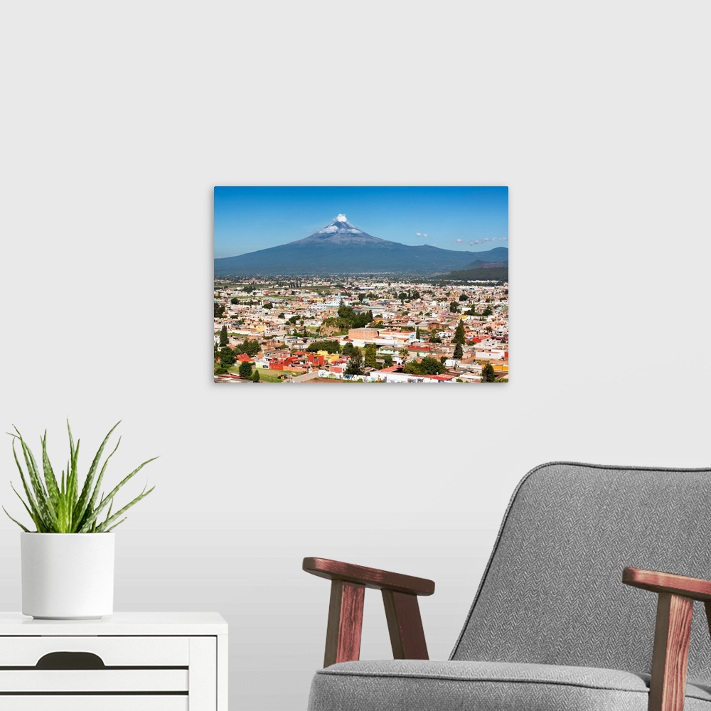 A modern room featuring Aerial photograph of the Popocatepetl Volcano in Puebla, Mexico, with a bird's eye view of the ci...