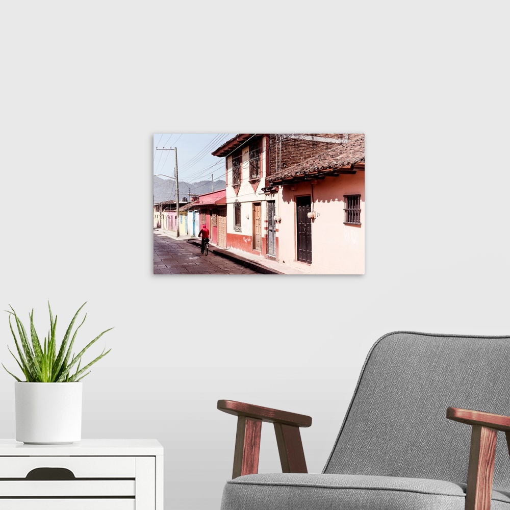 A modern room featuring Photograph of a streetscape in Mexico with a man in red riding a bike down the road. From the Viv...