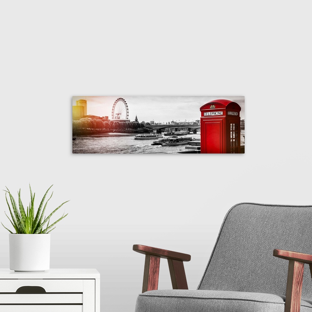 A modern room featuring An iconic red phone booth with the London Eye across the Thames, London, England.