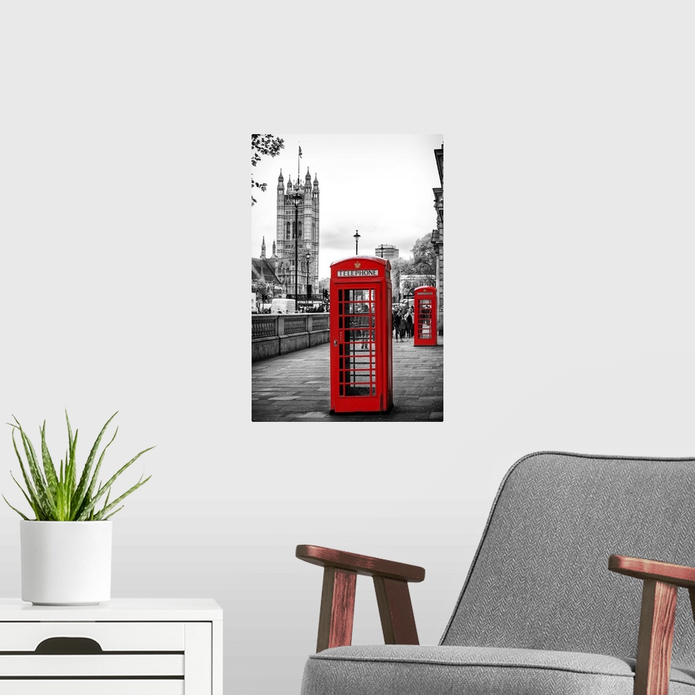 A modern room featuring Two red phone booths with the House of Parliament in the background, with selective coloring.