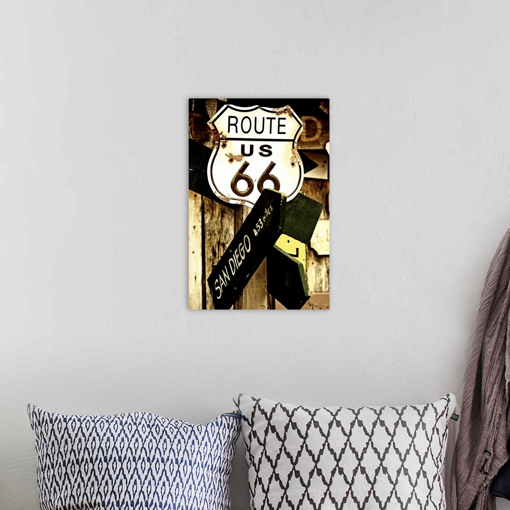 A bohemian room featuring A rusted metal sign for Route 66 and a direction sign pointing towards San Diego.