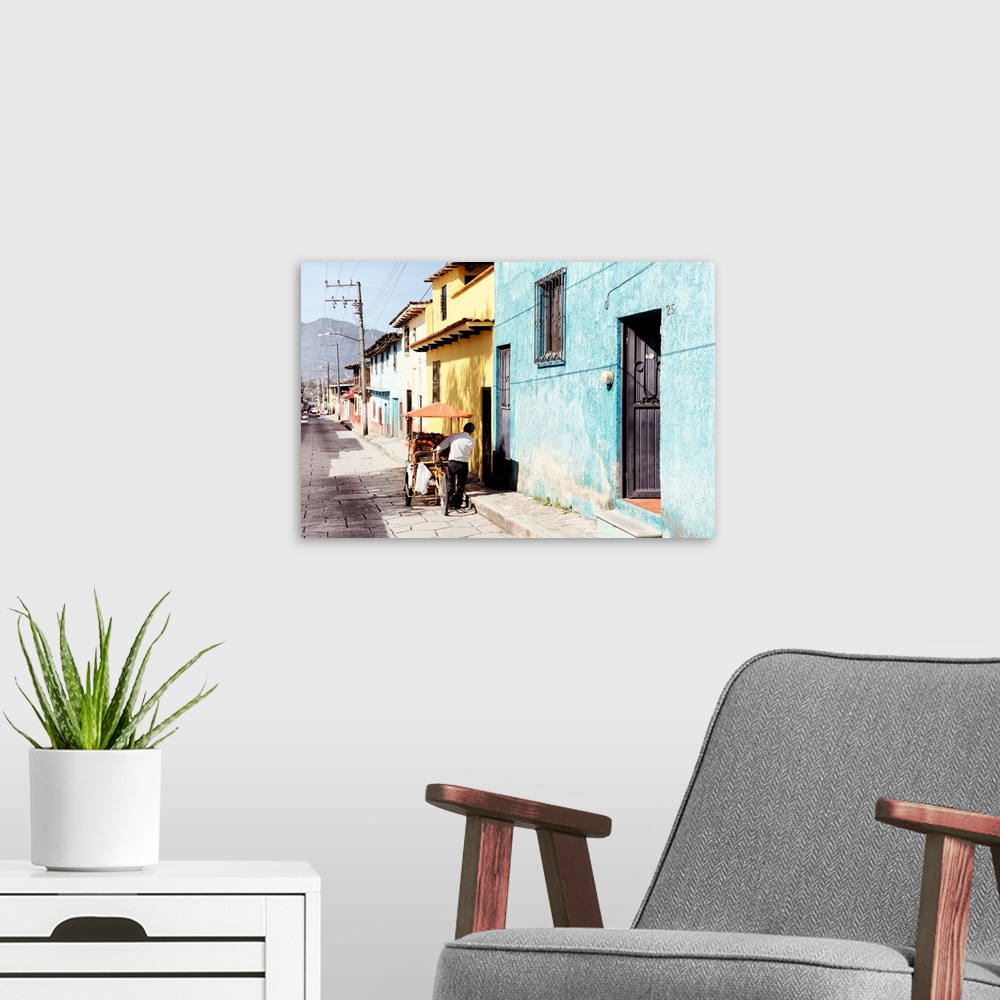 A modern room featuring Photograph of a street vendor pushing his cart full of fresh fruit down a colorful street in Mexi...