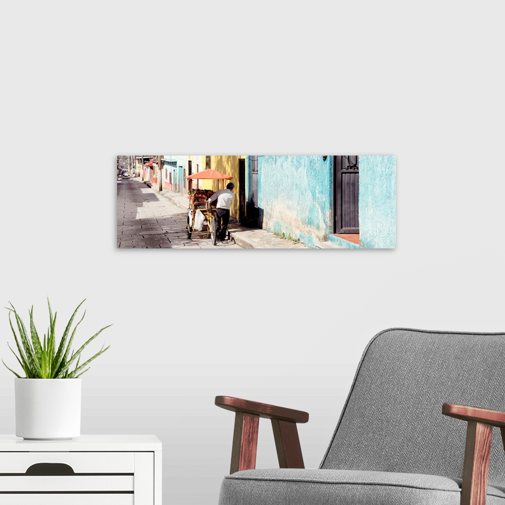 A modern room featuring Panoramic photograph of a street vendor pushing his cart full of fresh fruit down a colorful stre...