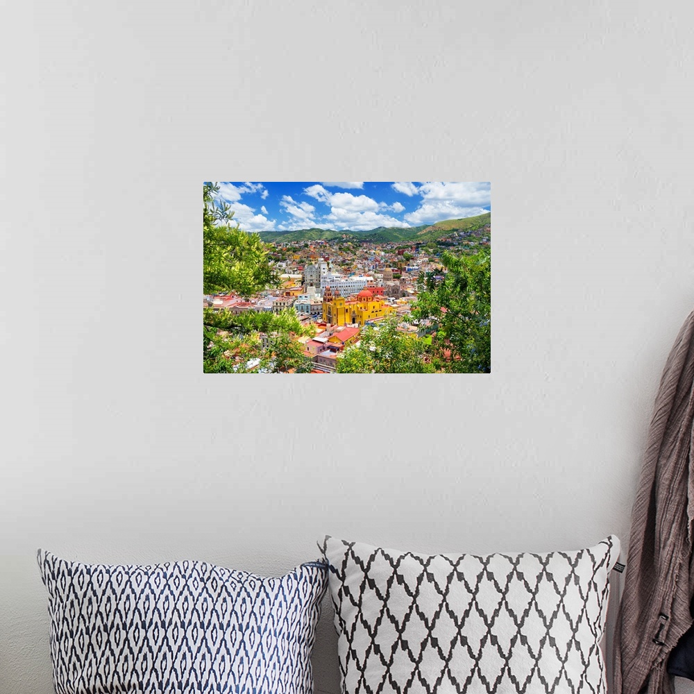 A bohemian room featuring Aerial photograph of a colorful cityscape in Guanajuato, mexico, framed by lush, green trees. Fro...