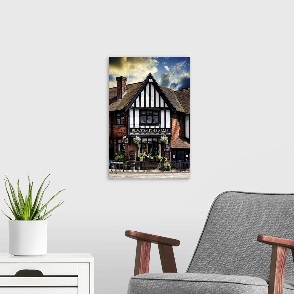 A modern room featuring Fine art photo of a quaint inn in the United Kingdom, an example of classic English architecture.