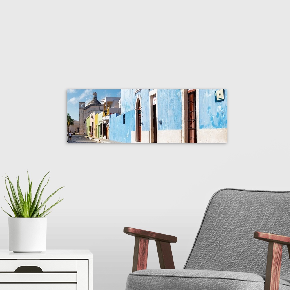 A modern room featuring Panoramic photograph of a street scene in Campeche, Mexico, with a bright blue building. From the...