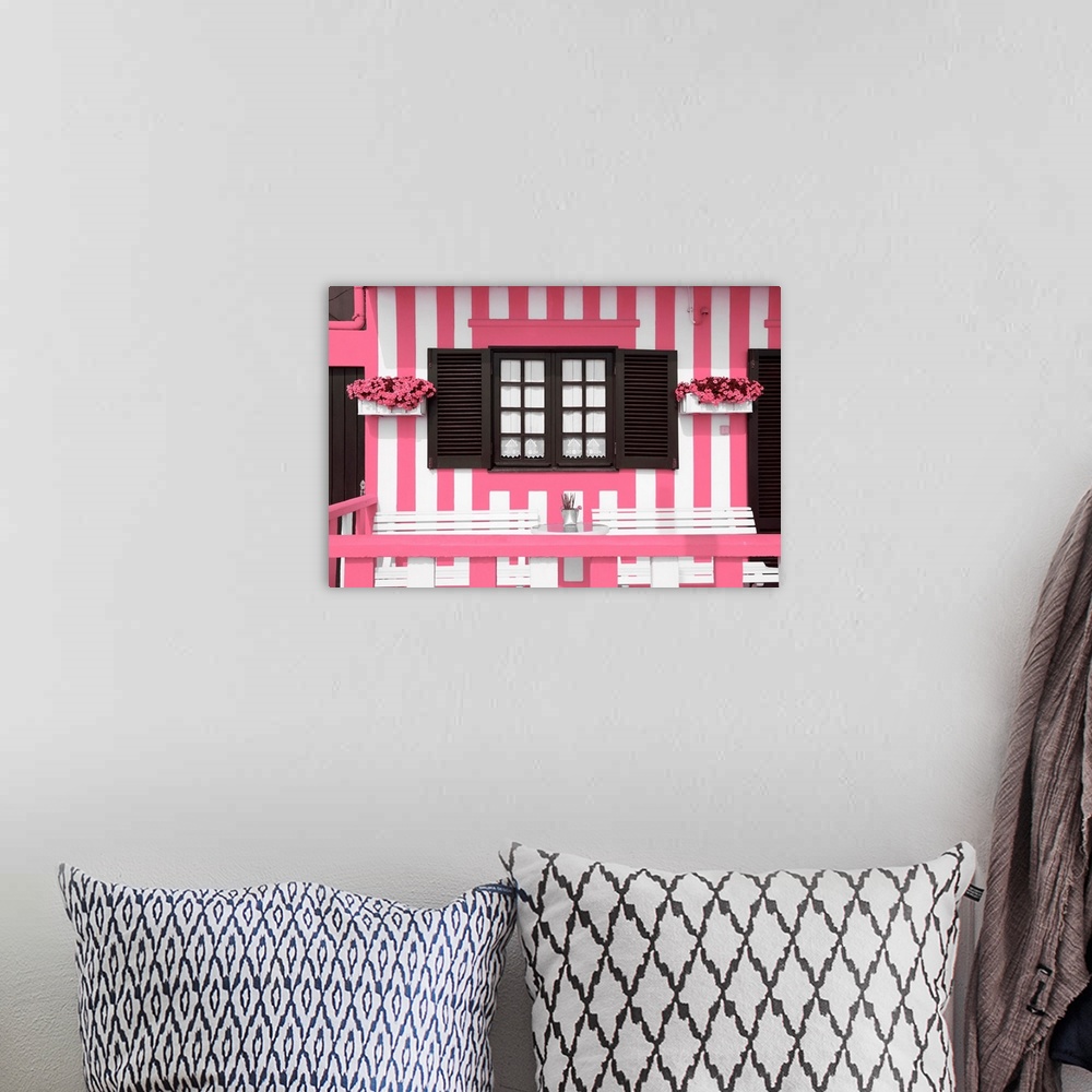 A bohemian room featuring It's a facade with pink stripes of traditional house in costa Nova beach in Portugal.