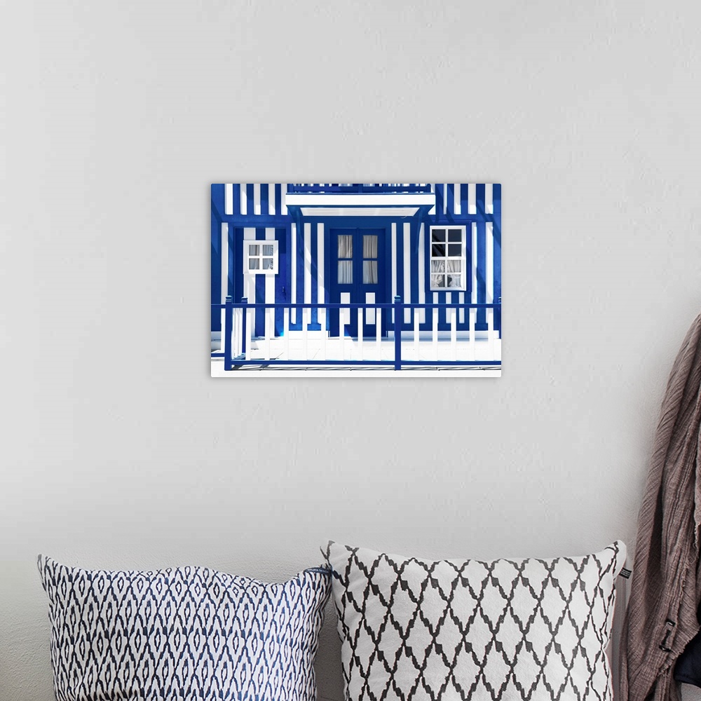 A bohemian room featuring It's a tradional white house facade with royal blue stripes in Costa Nova Beach, Portugal.