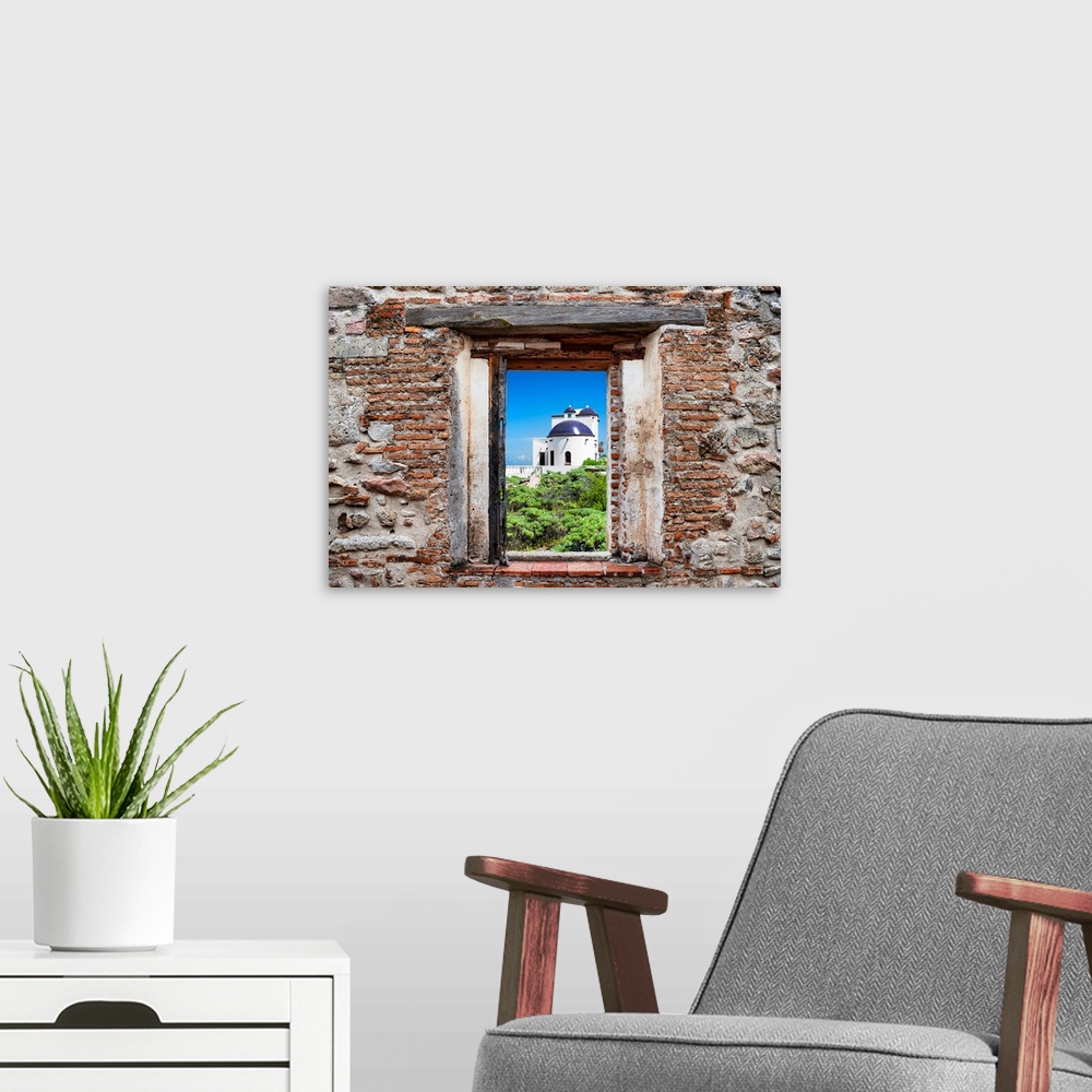 A modern room featuring View of a white house in Isla Mujeres, Mexico, framed through a stony, brick window. From the Viv...