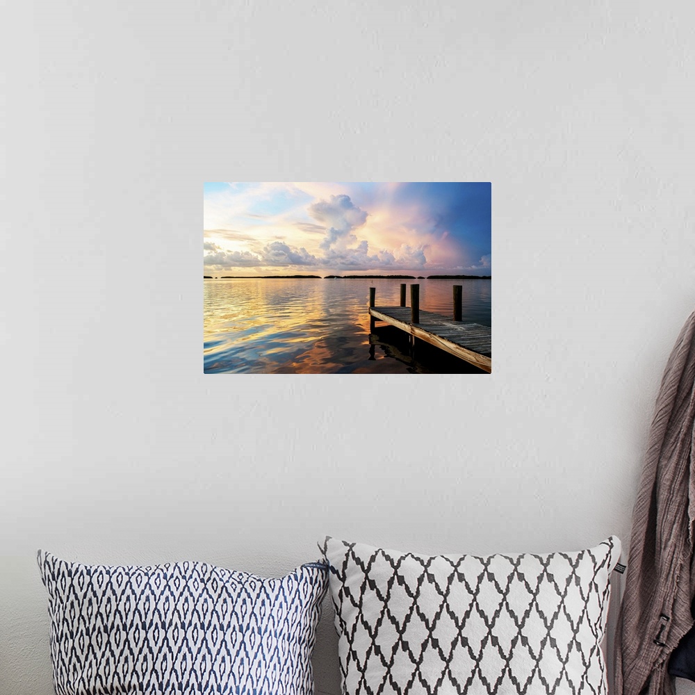 A bohemian room featuring A dock reaching out into the ocean at twilight with stunning clouds.