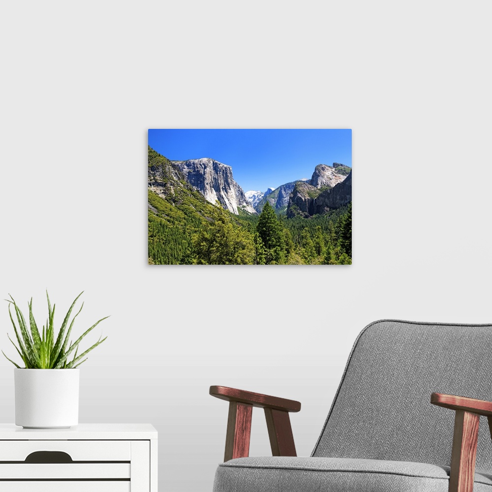 A modern room featuring The majestic peaks of Half Dome and its neighboring mountains over the forests of Yosemite Nation...
