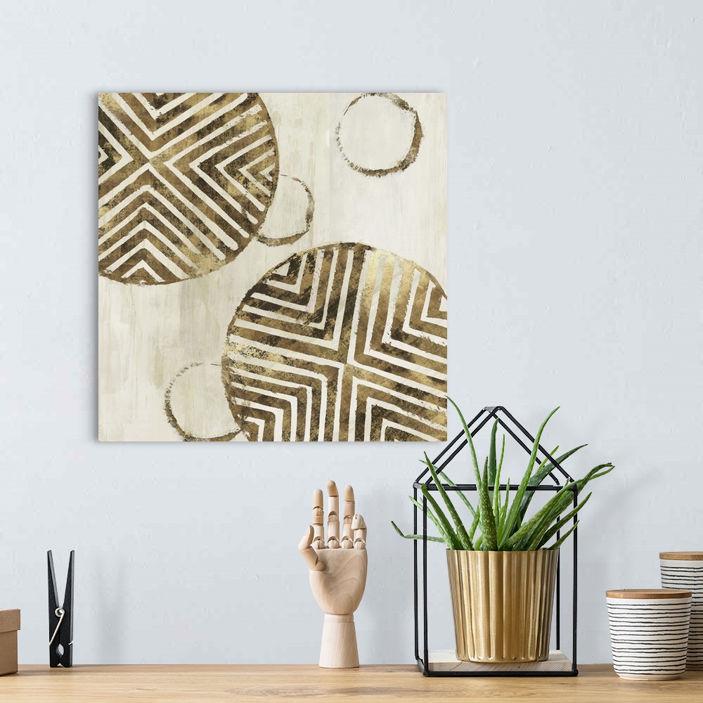 A bohemian room featuring Abstract art with metallic gold geometric circular shapes with lined designs on a light gold and ...