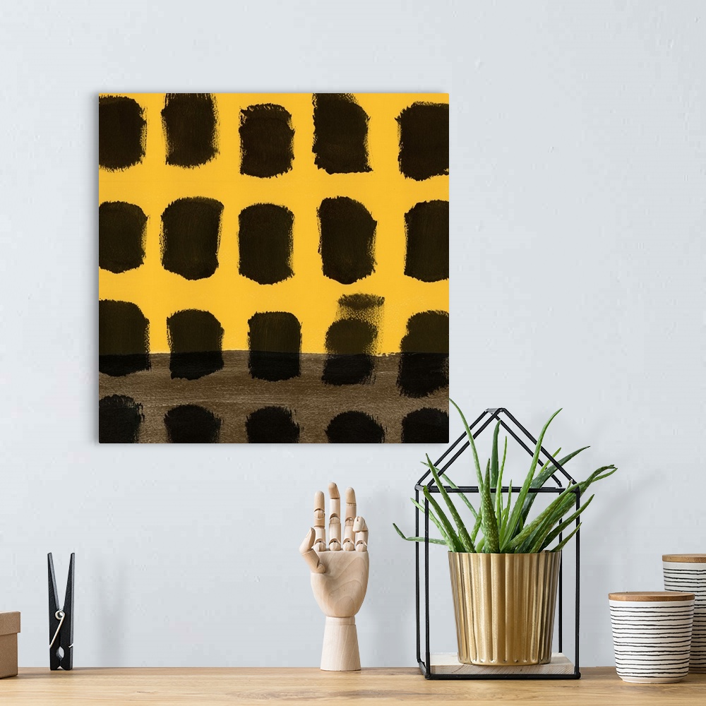 A bohemian room featuring Abstract art uses black squares to contrast the simple yellow background.