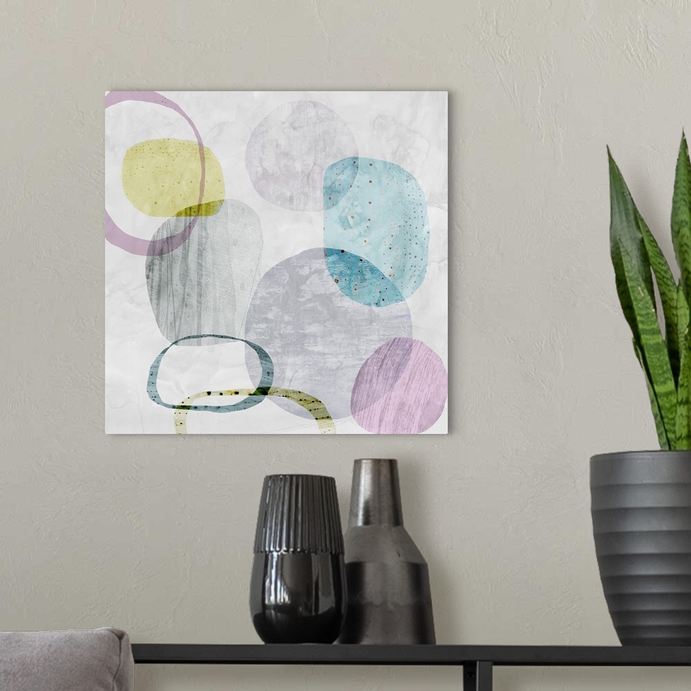 A modern room featuring Square artwork of circles and rings in multiple pale colors with a textured effect on top.
