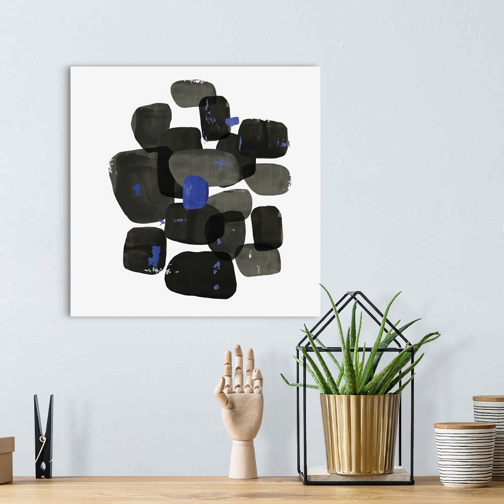 A bohemian room featuring Abstract painting of shapes of black with blue accents.