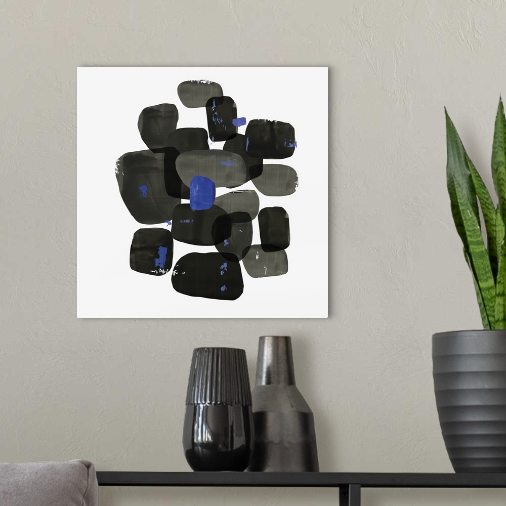 A modern room featuring Abstract painting of shapes of black with blue accents.