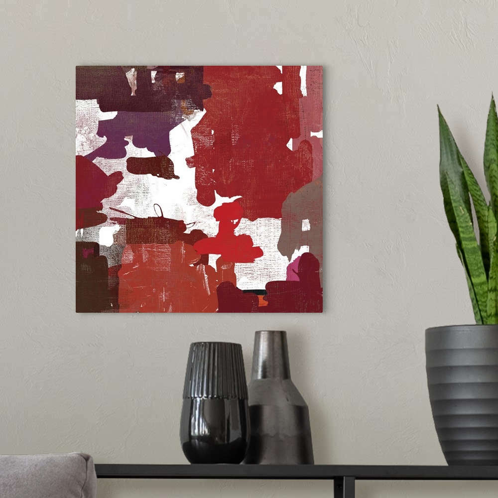 A modern room featuring A contemporary painting of abstract shapes in varies warm tones of red.