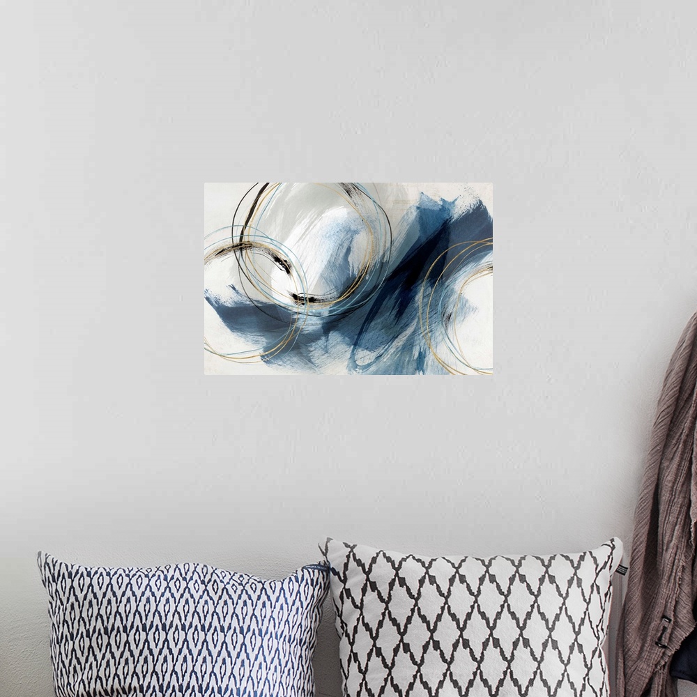 A bohemian room featuring Abstract painting with large blue brushstrokes and circular lines accented with gold.