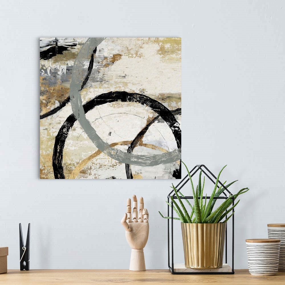 A bohemian room featuring Abstract artwork of overlapping rings in shades of grey, black, and gold.