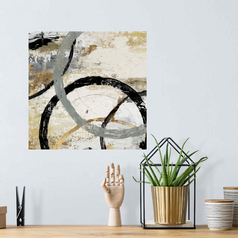 A bohemian room featuring Abstract artwork of overlapping rings in shades of grey, black, and gold.