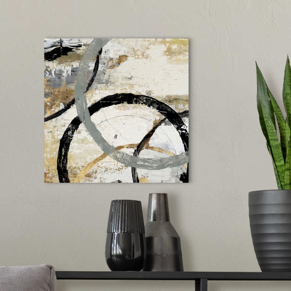 A modern room featuring Abstract artwork of overlapping rings in shades of grey, black, and gold.