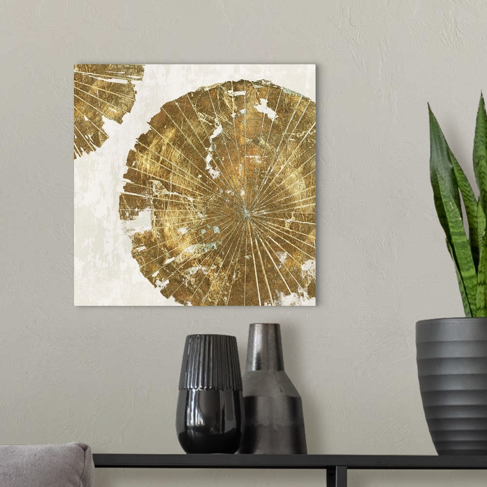 A modern room featuring Abstract artwork of circular forms resembling tree rings in gold.