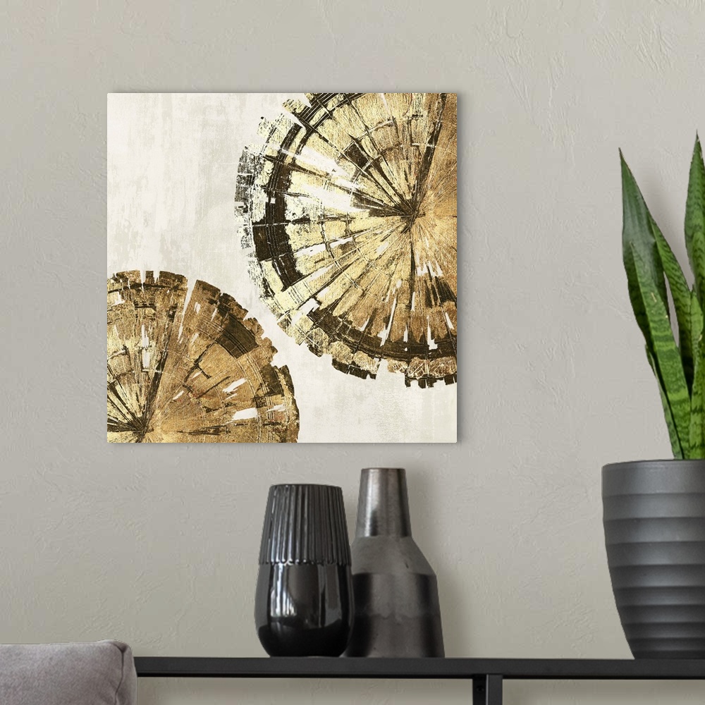 A modern room featuring Abstract artwork of circular forms resembling tree rings in gold.