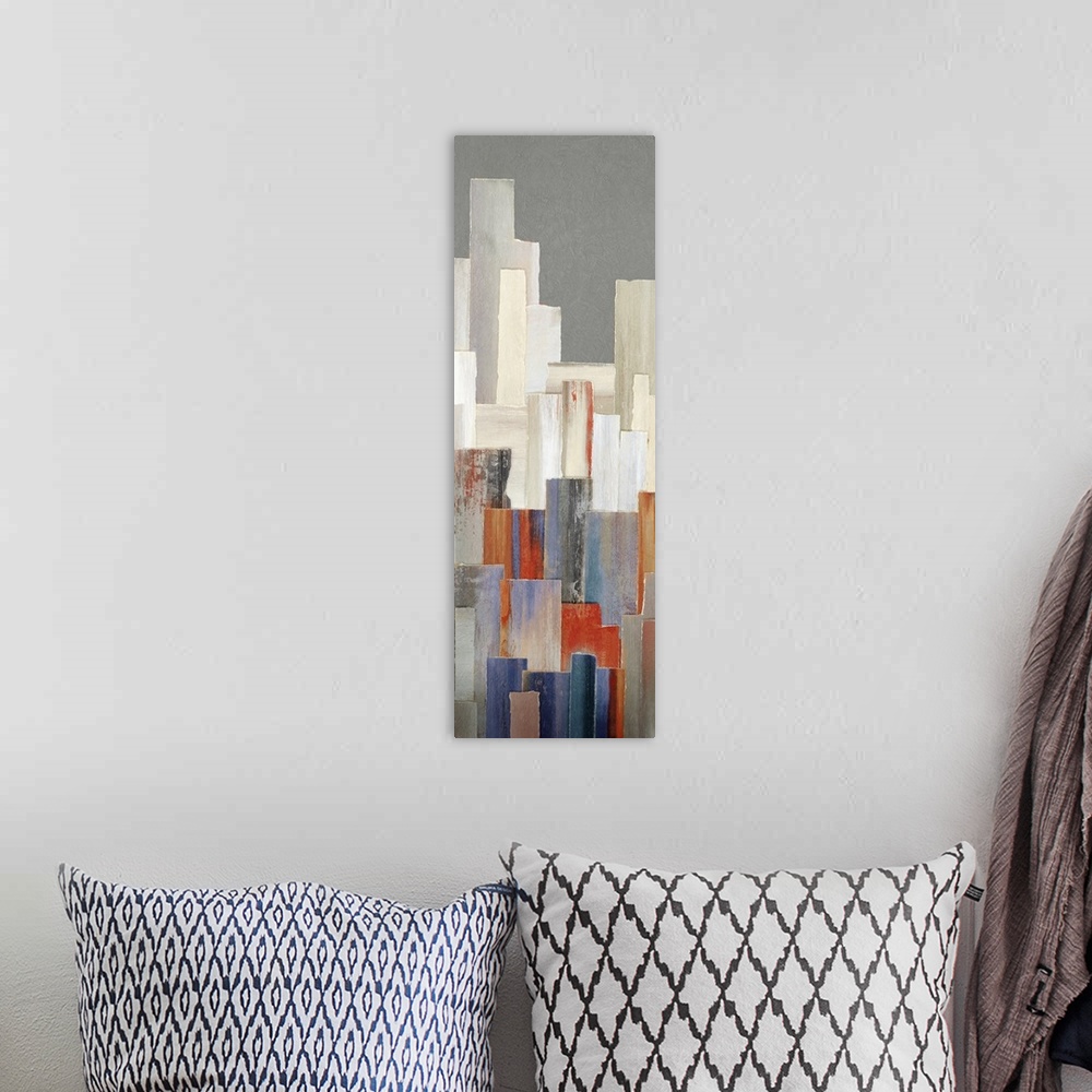 A bohemian room featuring A long vertical contemporary painting of multi colored buildings in a city.