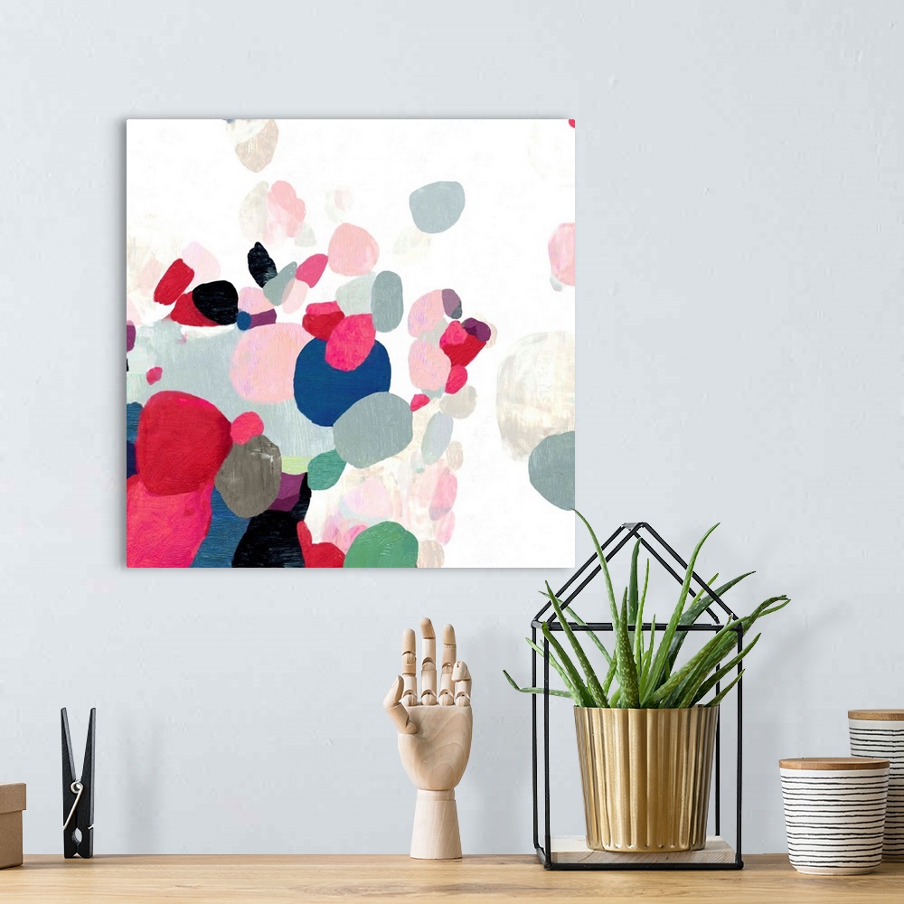 A bohemian room featuring Square painting of varies sized circles in multiple colors on a textured white backdrop.