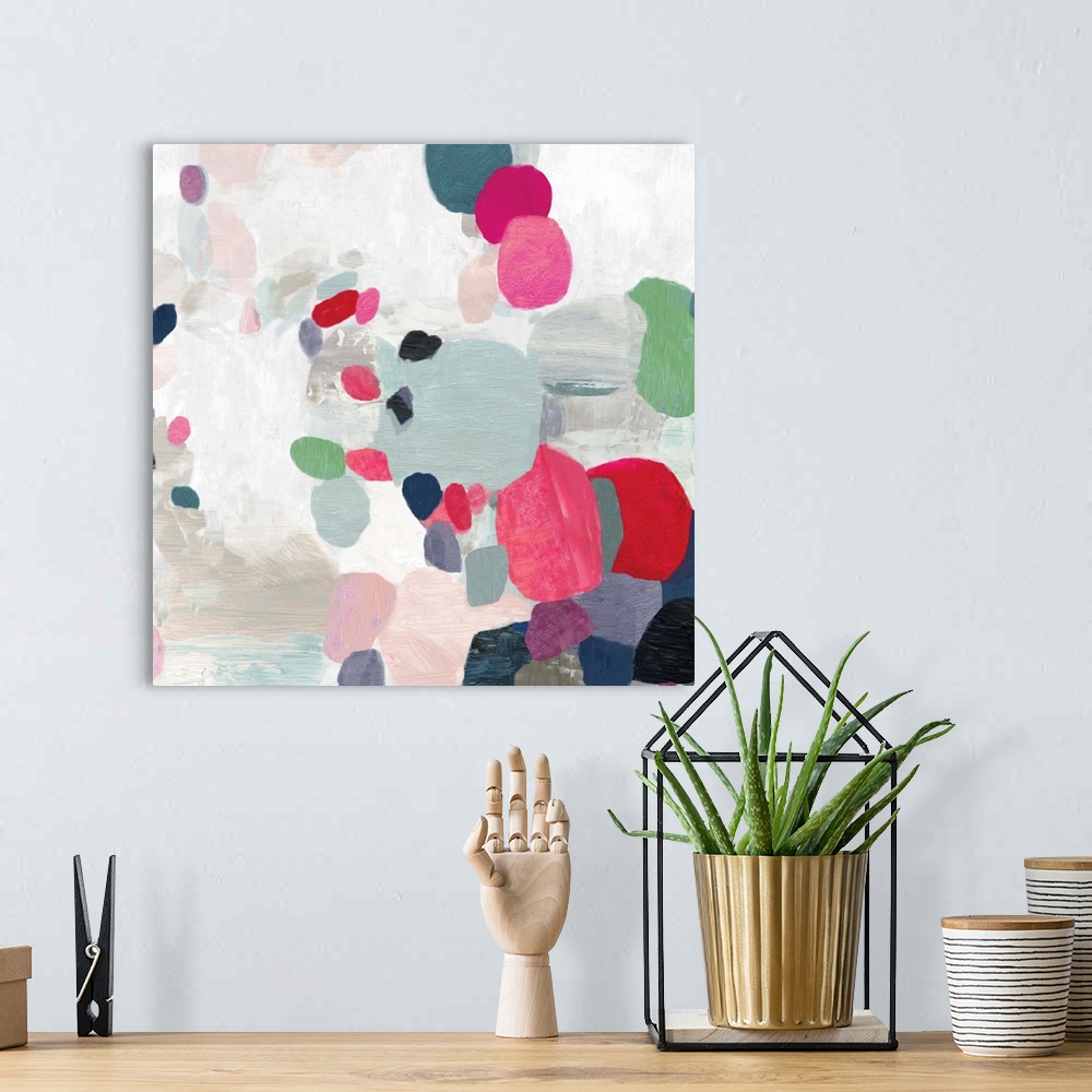 A bohemian room featuring Square painting of varies sized circles in multiple colors on a textured white backdrop.