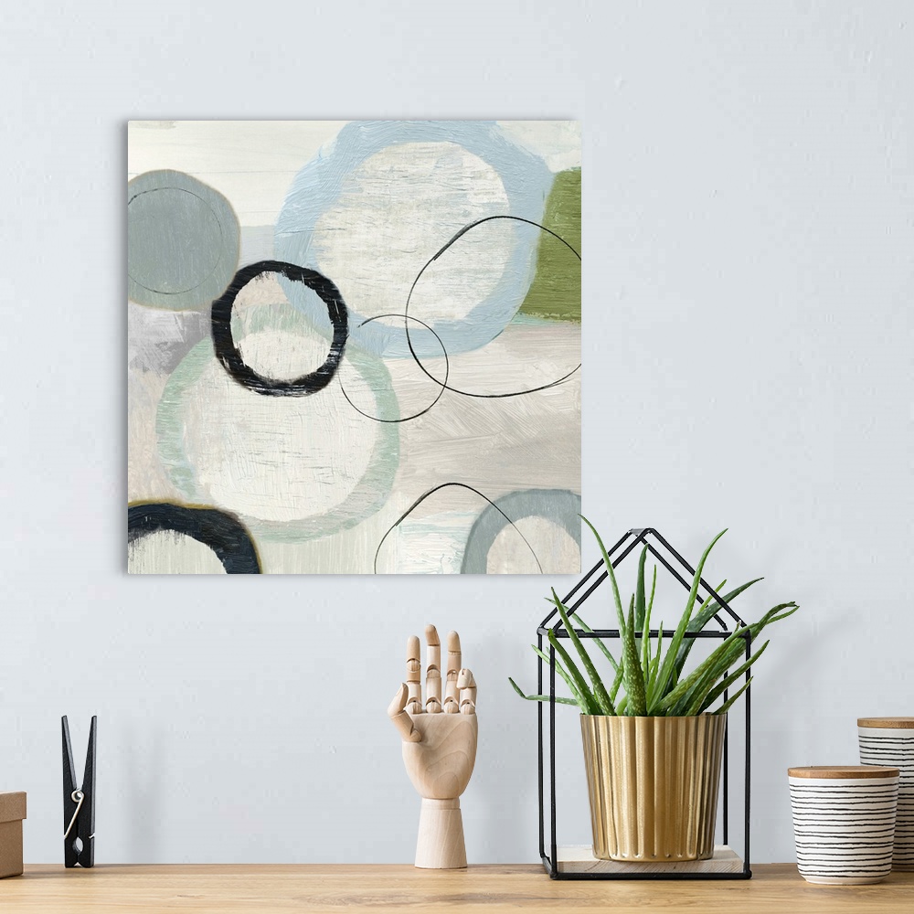 A bohemian room featuring An abstract painting of circles in varies sizes and colors.